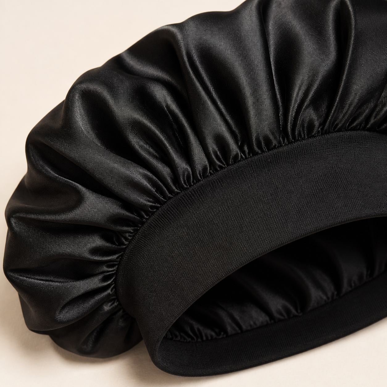 Close-up of black satin bonnet fabric and wide stretch band