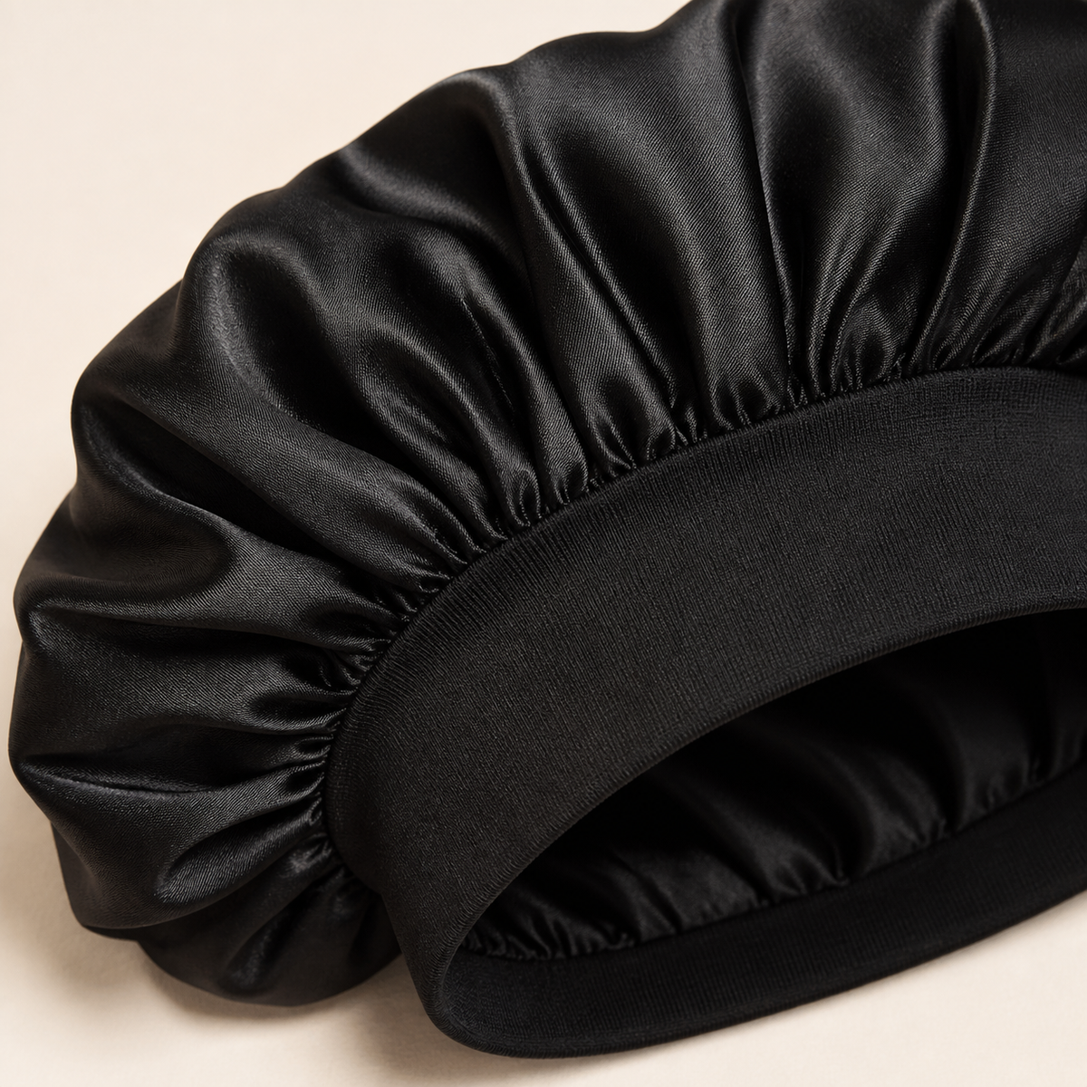 Close-up of black satin bonnet fabric and wide stretch band
